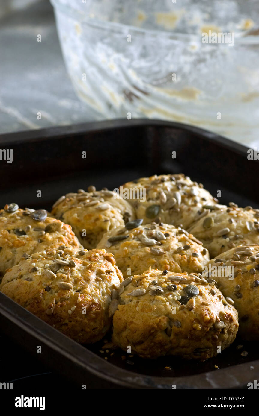 Graines mixtes nutritifs et des scones au fromage frais du four. Photographié à l'aide de la lumière naturelle pour un usage éditorial. Banque D'Images