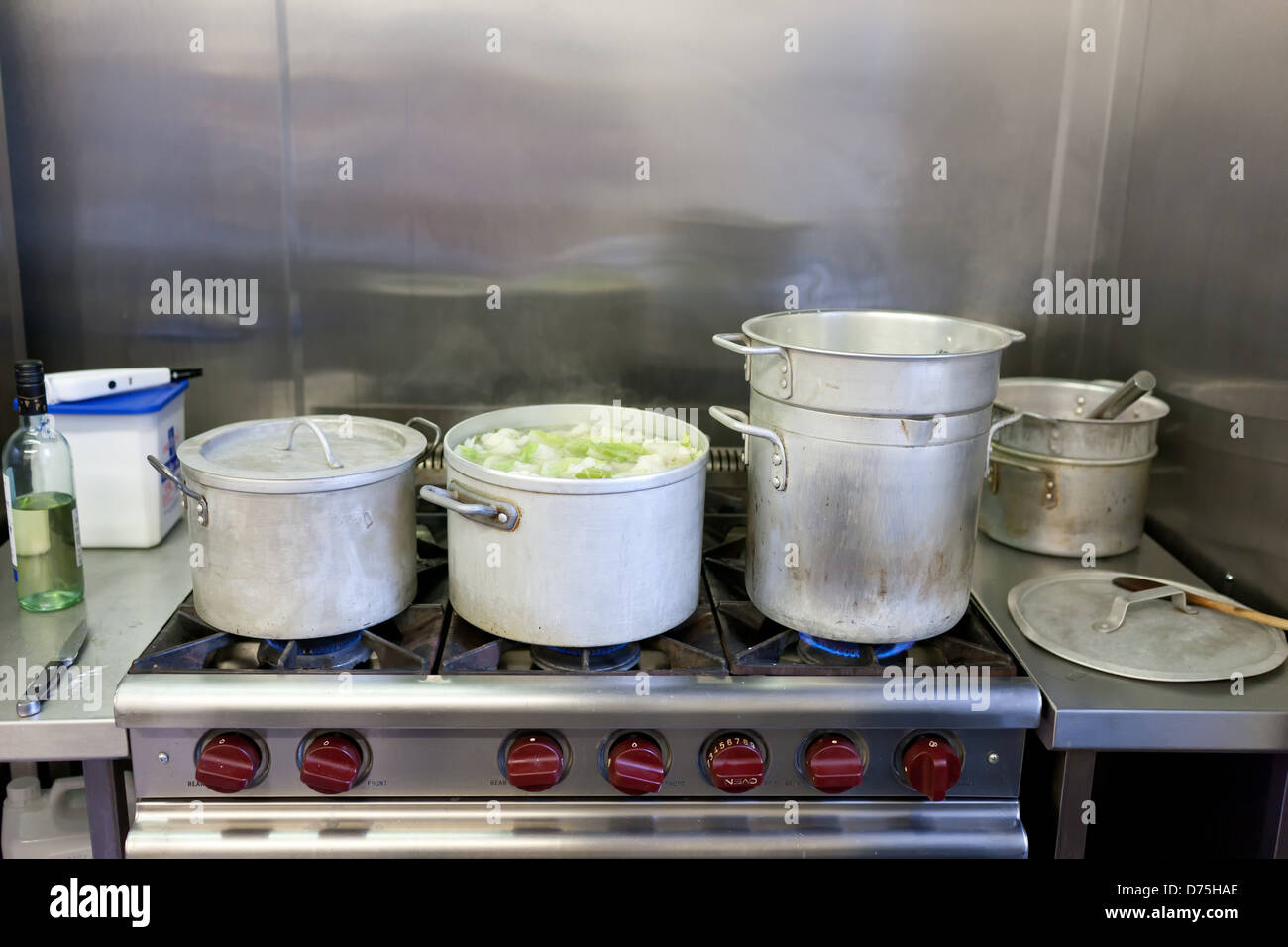 Gros pots en aluminium de légumes sur la cuisinière à gaz industriel professionnel cuisine cooking in restaurant kitchen Banque D'Images