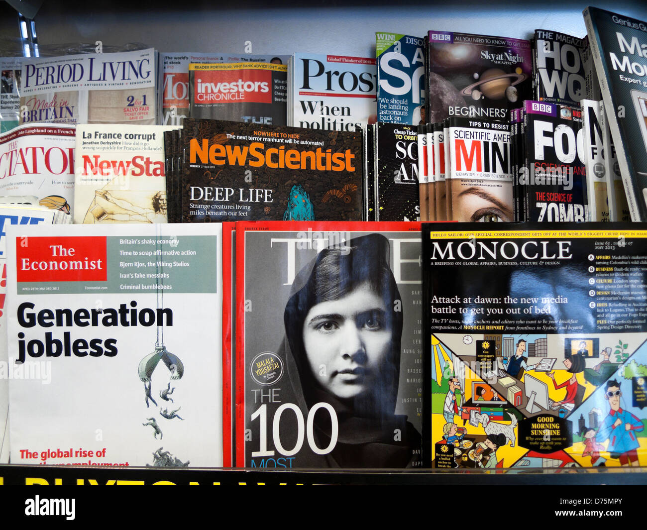 Malala Yousafzai sur la couverture du magazine Time sur des étagères à côté de l'Économiste, New Scientist & Monocle au marchand de WH Smith London England UK Banque D'Images