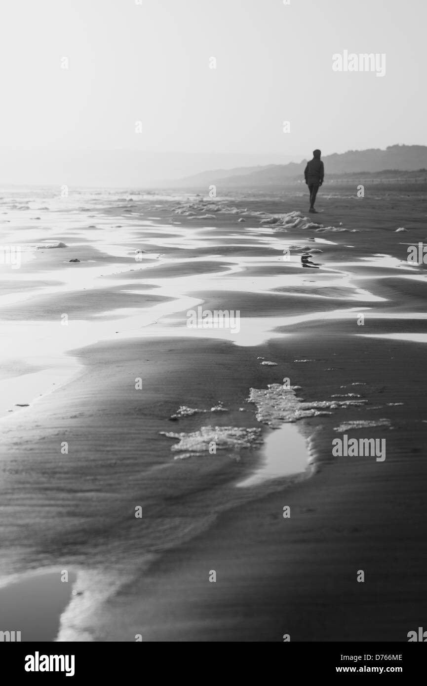 Personne solitaire sur une plage d'hiver, image en noir et blanc Banque D'Images