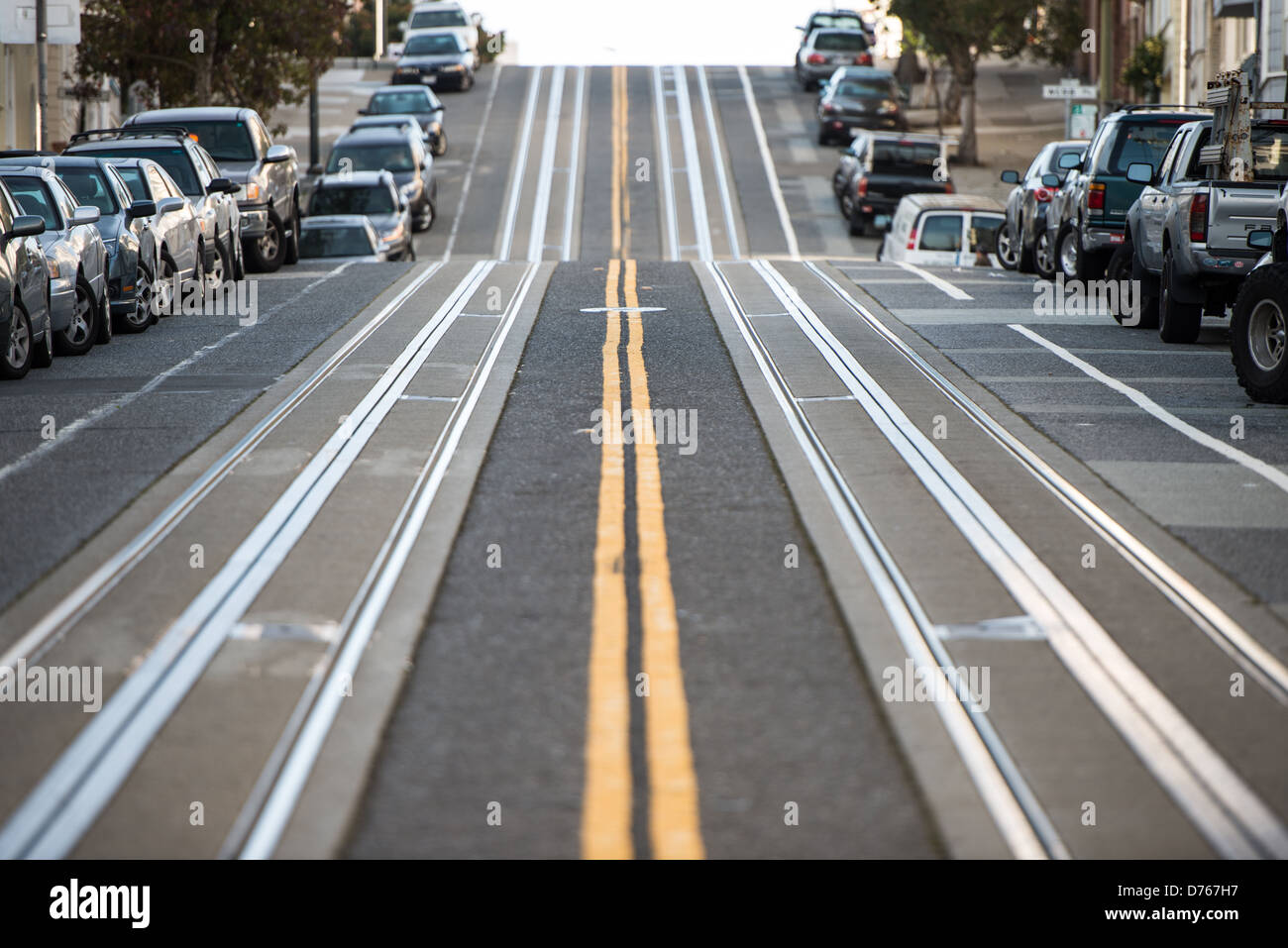 Hyde Street San Francisco // SAN FRANCISCO — des pistes de téléphérique en métal sont intégrées dans le trottoir escarpé de Hyde Street à son intersection avec Filbert Street dans le quartier de North Beach. La ligne de téléphérique Hyde Street fait partie du système historique de téléphériques de San Francisco, qui a fonctionné en continu depuis la fin du XIXe siècle. La pente raide de Hyde Street, comme beaucoup de collines de San Francisco, nécessite le mécanisme de préhension unique du système de téléphérique pour tirer les voitures vers le haut des pentes qui seraient impossibles pour les tramways conventionnels. Le quartier de North Beach, situé sur la Banque D'Images