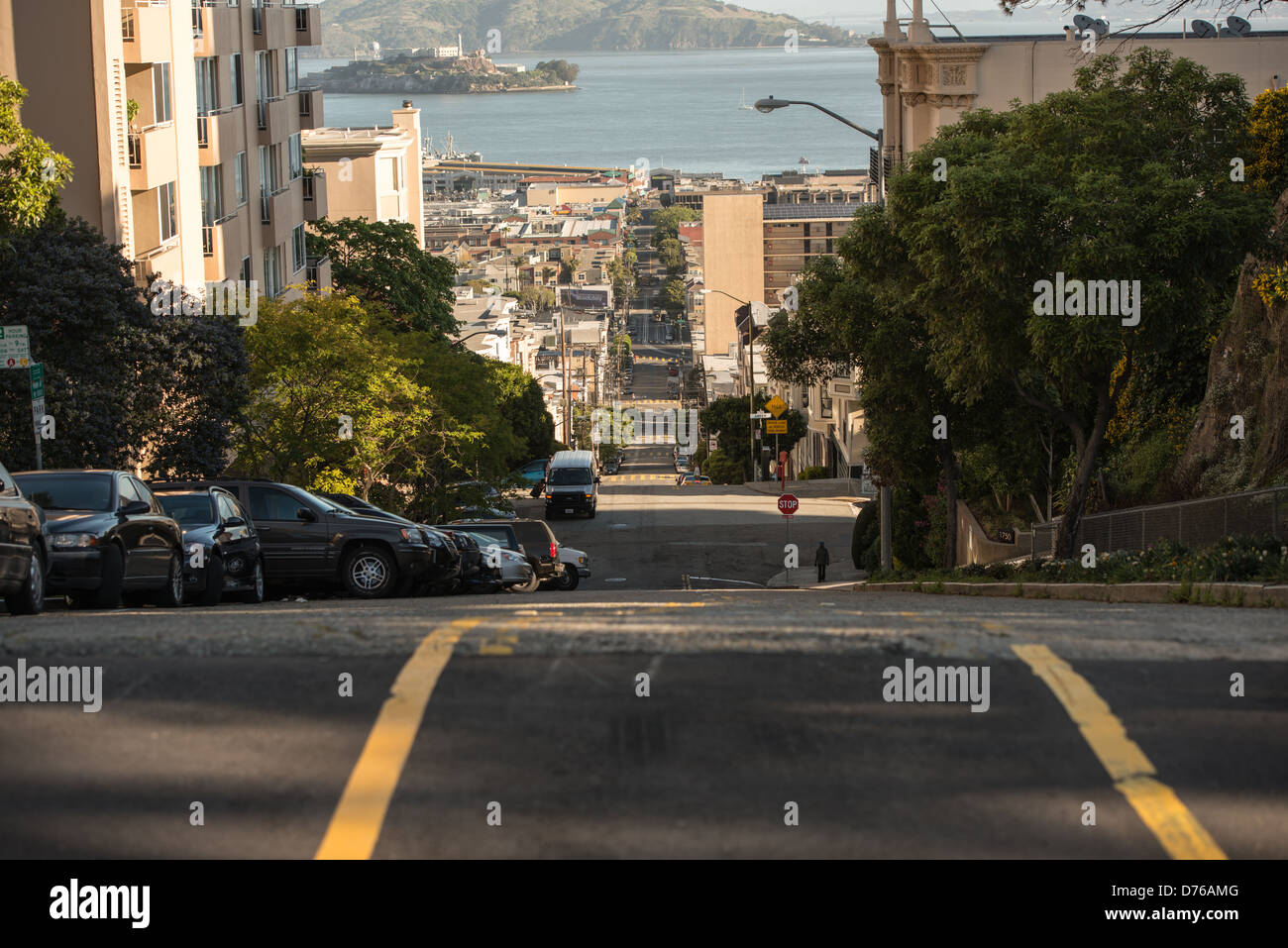 Taylor Street Steep Hill Alcatraz View San Francisco Californie // SAN FRANCISCO, Californie — Taylor Street descend abruptement à travers le quartier de North Beach à San Francisco, offrant une vue sur l'île d'Alcatraz et la baie de San Francisco. La rue fait partie des célèbres artères escarpées de la ville qui caractérisent le terrain vallonné de San Francisco. North Beach, situé sur le front de mer nord, est largement connu comme le quartier italo-américain de la ville et le centre historique de la culture Beat Generation. L'île d'Alcatraz, visible au loin de l'autre côté de la baie, a servi de prison fédérale de 1934 à 196 Banque D'Images