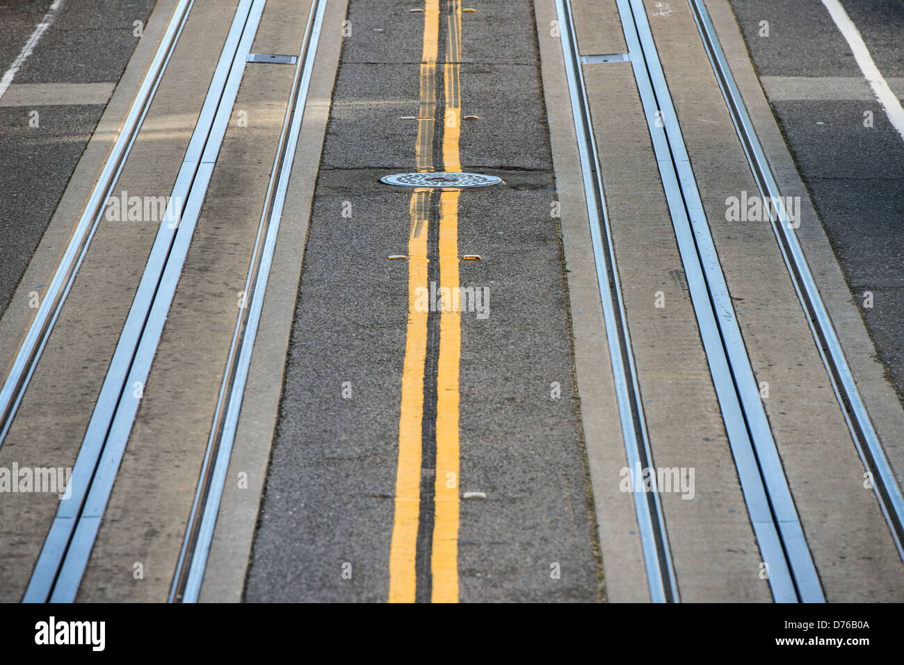 Pistes de téléphérique San Francisco Californie // SAN FRANCISCO, Californie — les pistes de téléphérique sont encastrées dans le trottoir de l'une des rues escarpées de San Francisco. Le système de téléphérique de la ville, qui a commencé à fonctionner en 1873, utilise un réseau de câbles souterrains pour tirer les voitures le long du terrain difficile de la ville. Les téléphériques de San Francisco sont parmi les rares systèmes de téléphériques à commande manuelle encore utilisés dans le monde entier et ont été désignés National Historic Landmark en 1964. La topographie abrupte qui a nécessité ce système de transport est une caractéristique déterminante de San Francis Banque D'Images