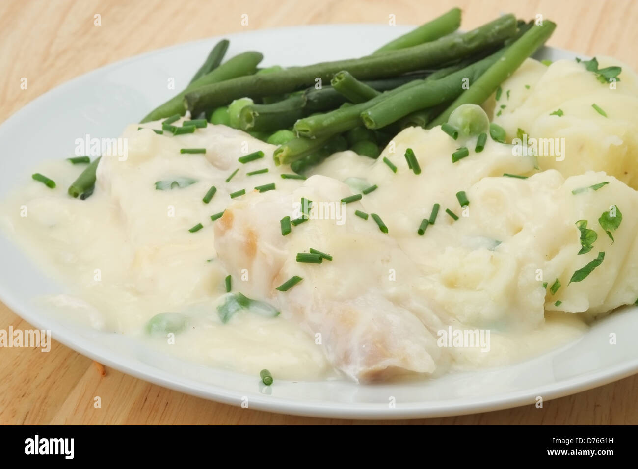 Cod Mornay avec purée de pommes de terre, pois, haricots verts et une sauce à la crème et blanc Banque D'Images