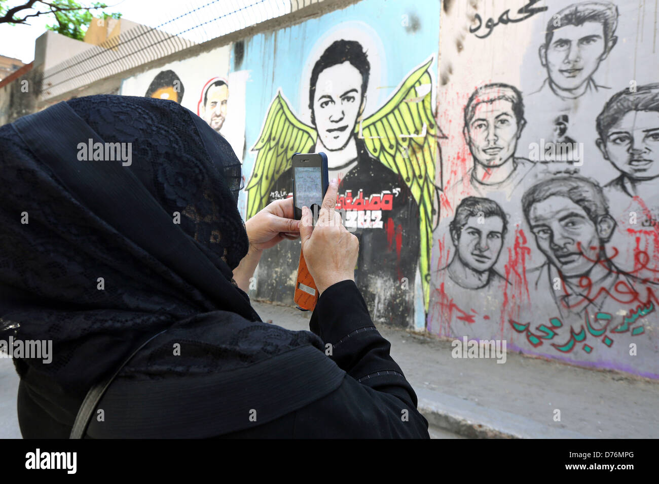 Femme prend des photos d'une fresque révolutionnaire sur un mur des martyrs près de la place Tahrir au Caire. Banque D'Images