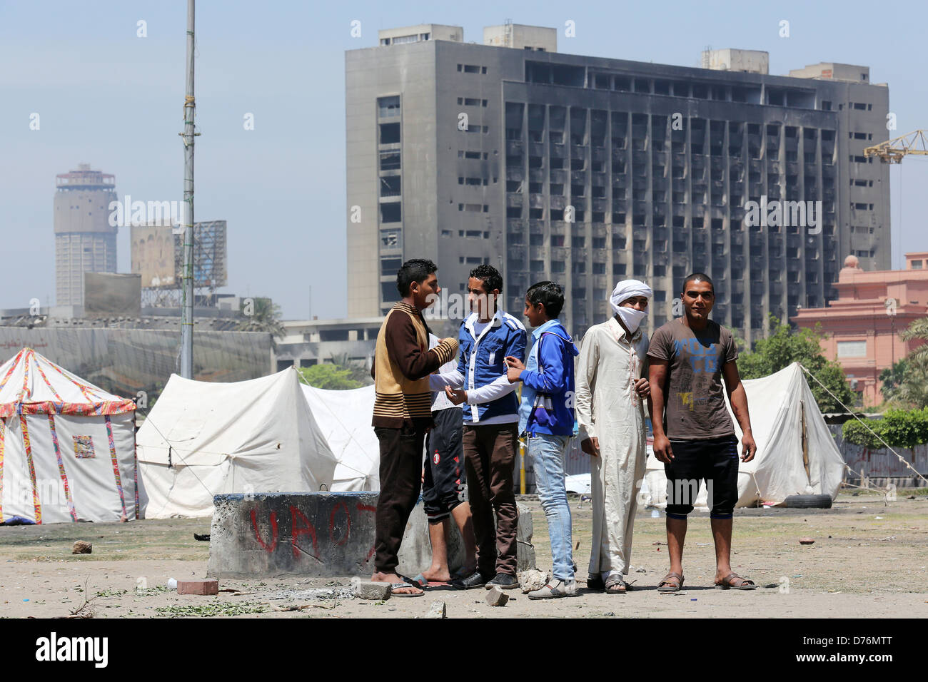 Le Caire, Égypte. Des tentes sur la place Tahrir. Dans l'arrière-plan le siège incendié du NPD, parti national démocratique Le Caire Banque D'Images
