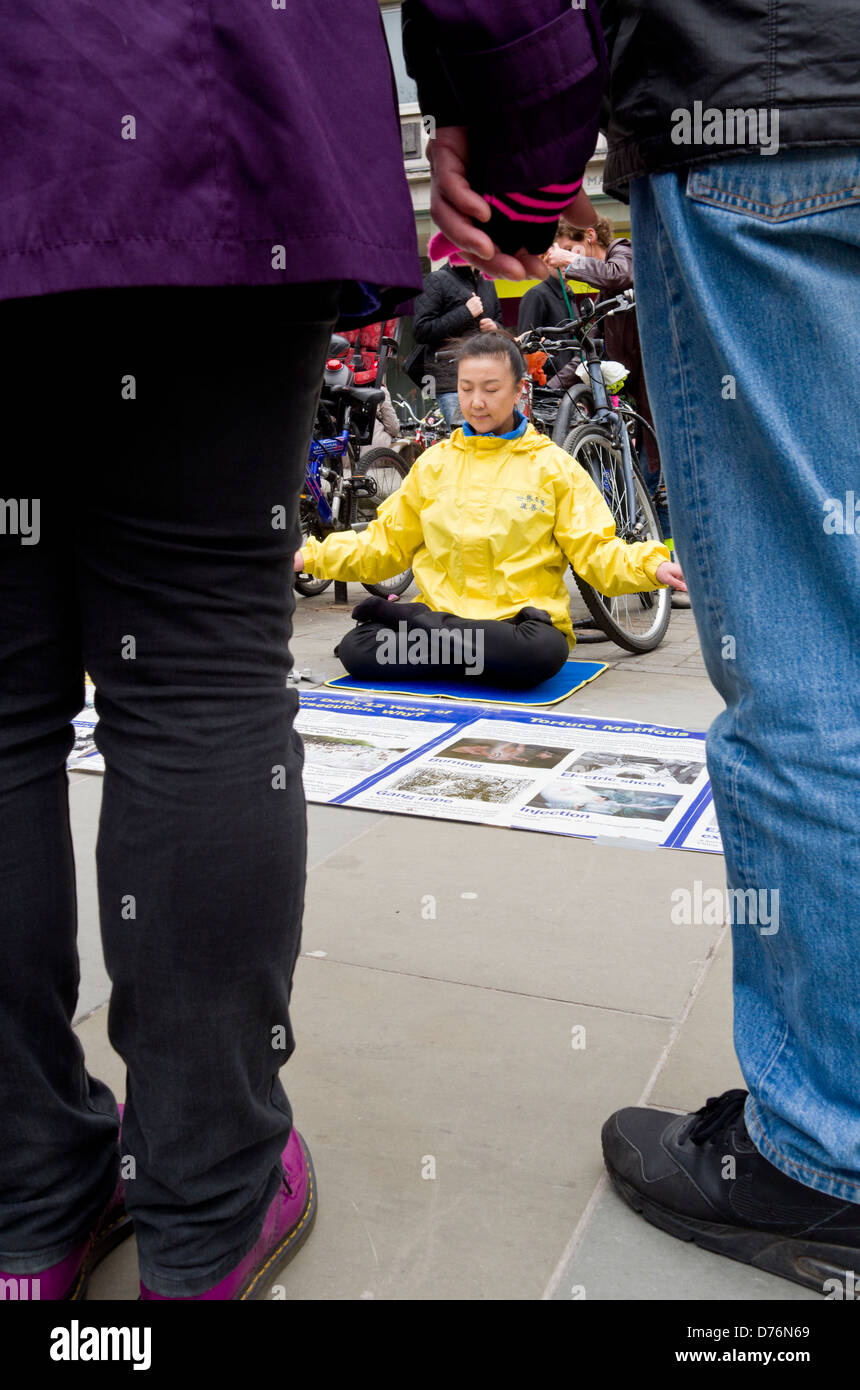 Couple Holding Hands, regardant un Falun Gong méditant. Banque D'Images