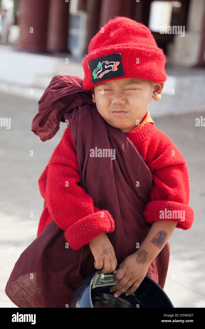 Petit garçon dans la robe de moine et red hat avec sa collection bol 6 Banque D'Images