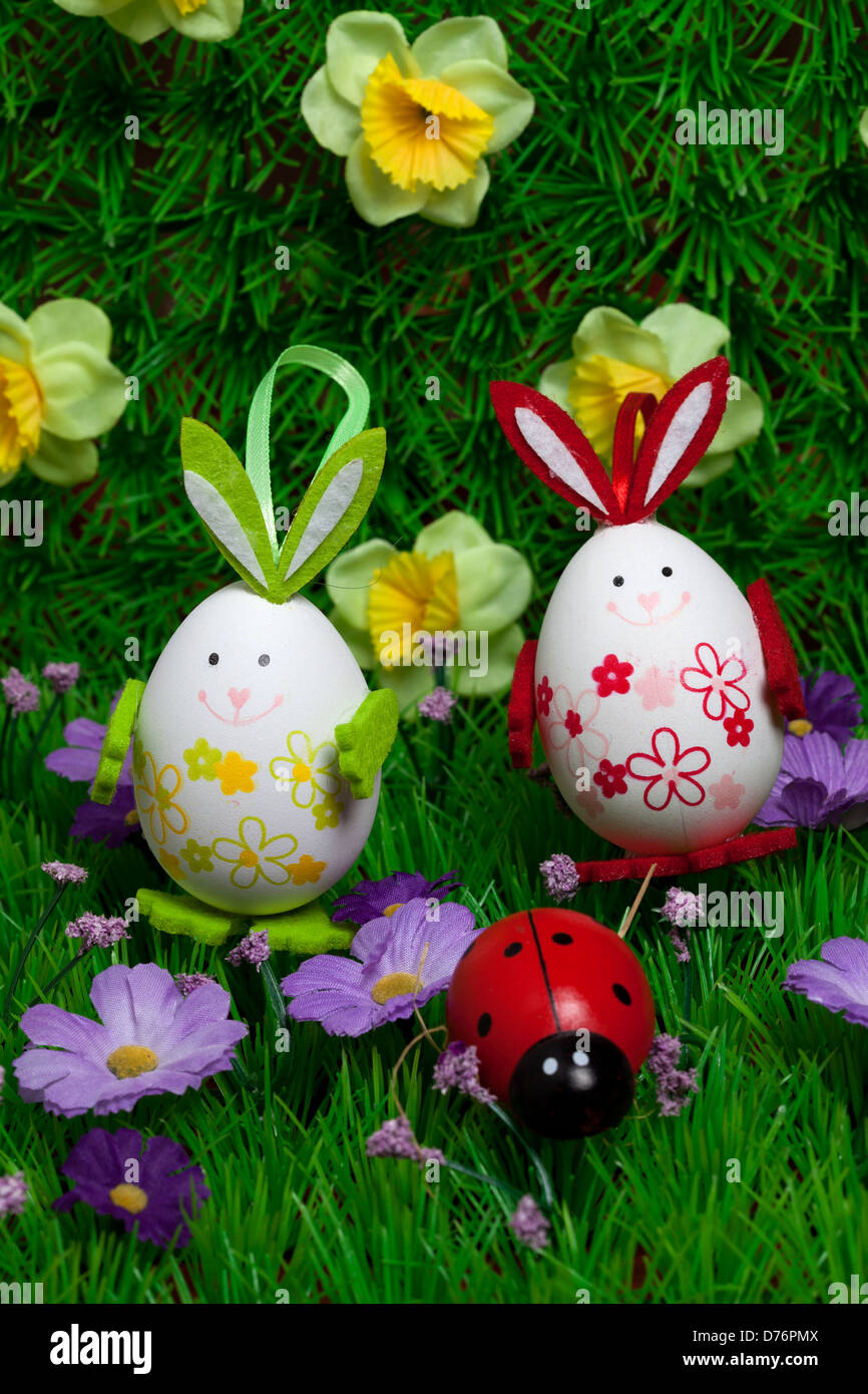 Les oeufs colorés dans l'herbe avec des fleurs et lillac,Pâques, Banque D'Images