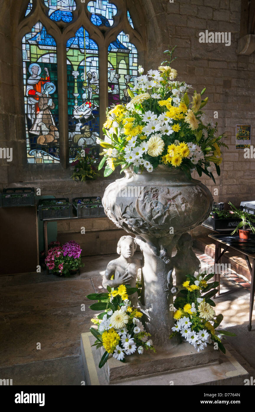 Arrangement floral dans la police de l'église All Saints Moulton, Lincolnshire, Angleterre, RU Banque D'Images