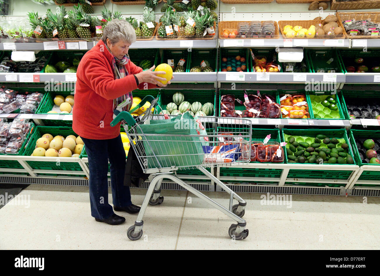 Une dame d'âge moyen d'acheter des fruits dans un supermarché Waitrose, Suffolk, UK Banque D'Images