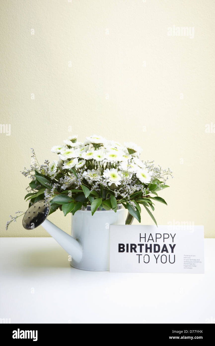 Une carte disant joyeux anniversaire à vous à côté de fleurs blanches en  arrosoir blanc Photo Stock - Alamy