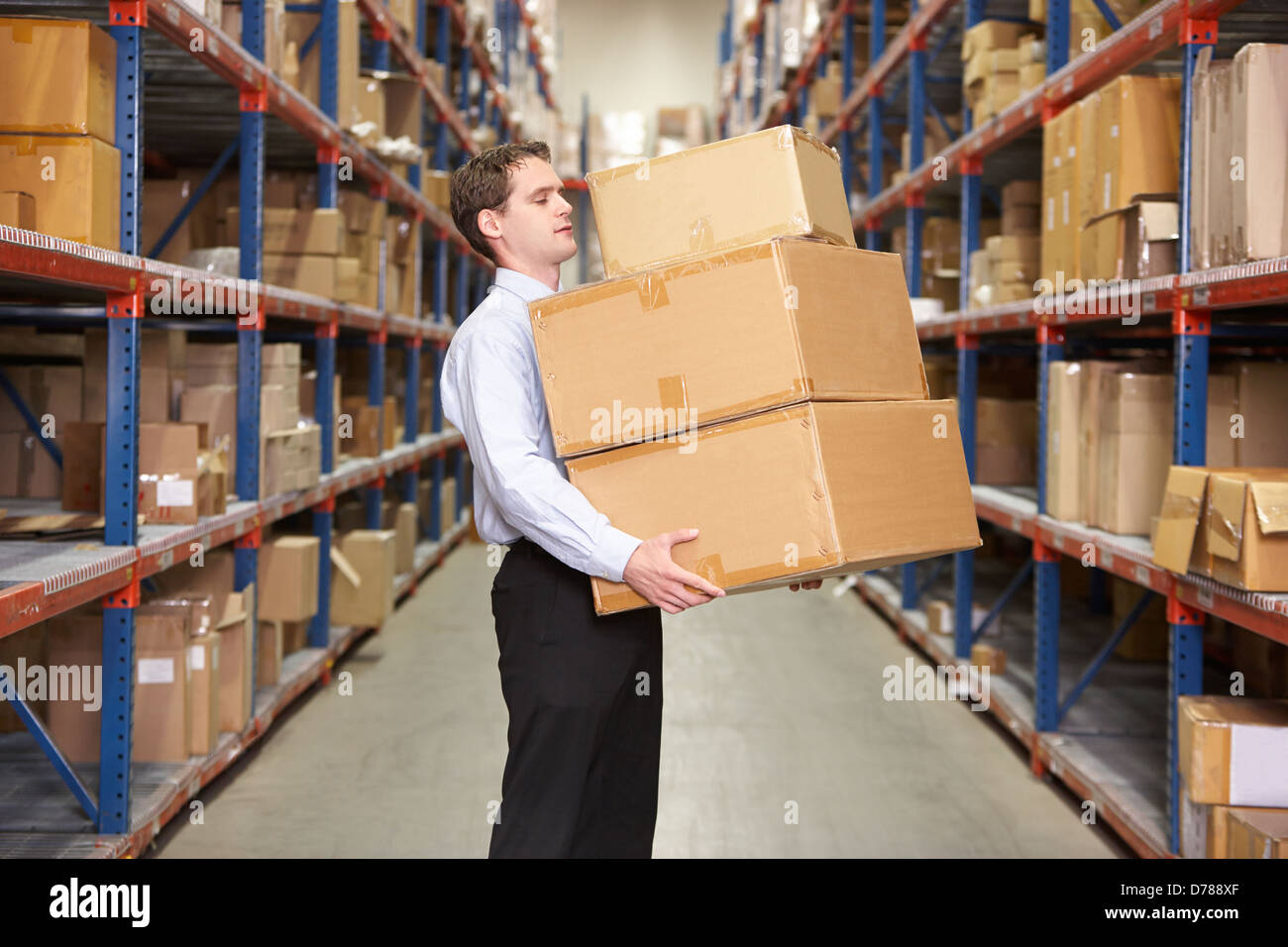 Man Carrying Boxes In Warehouse Banque D'Images