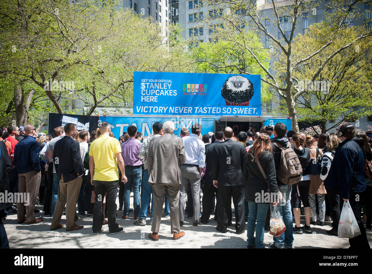 Heureux les amateurs de hockey et d'autres visiteurs get free articles promotionnels cupcakes au Madison Square Park de New York Banque D'Images