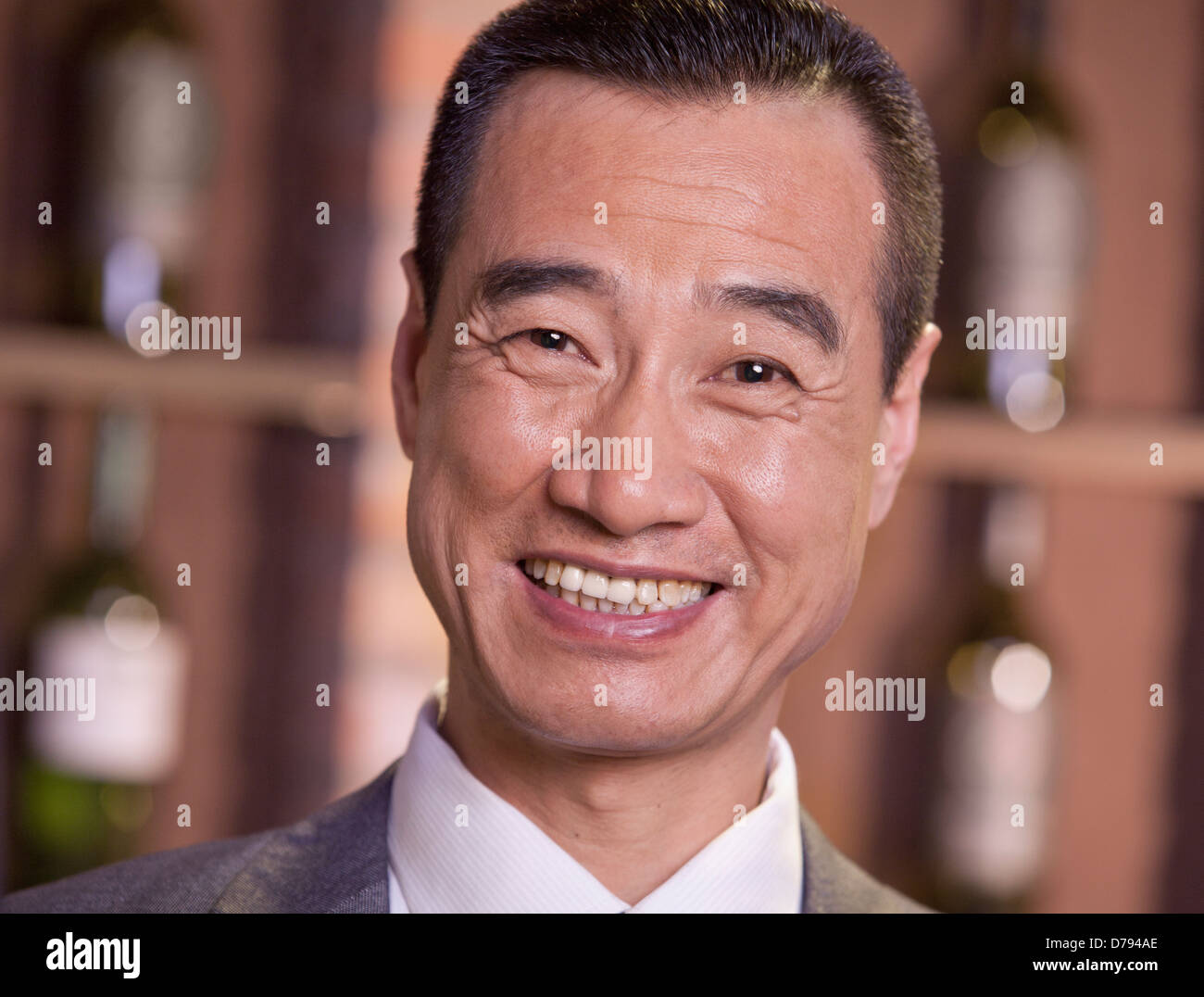 Smiling businessman standing par des bouteilles de vin, Close Up Banque D'Images