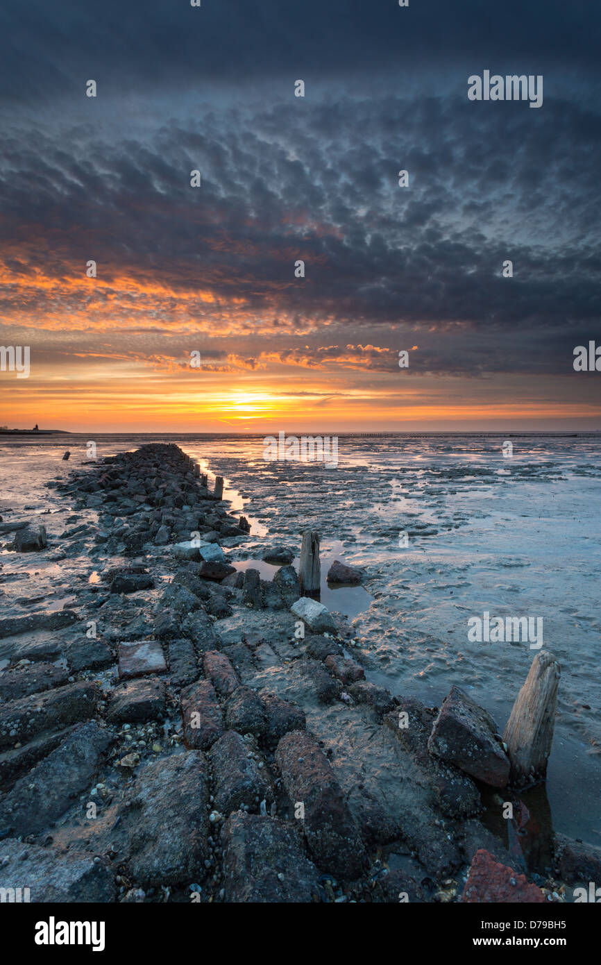 Barrière de rochers à la mer des Wadden avec les derniers rayons du soleil au crépuscule Banque D'Images