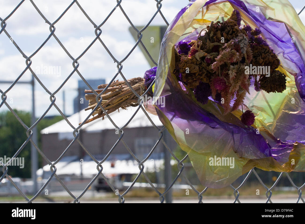 bouquet sec de fleurs laissé par un deuil. Coincé dans une barrière à maillons de chaîne et le site de la tragédie. Banque D'Images