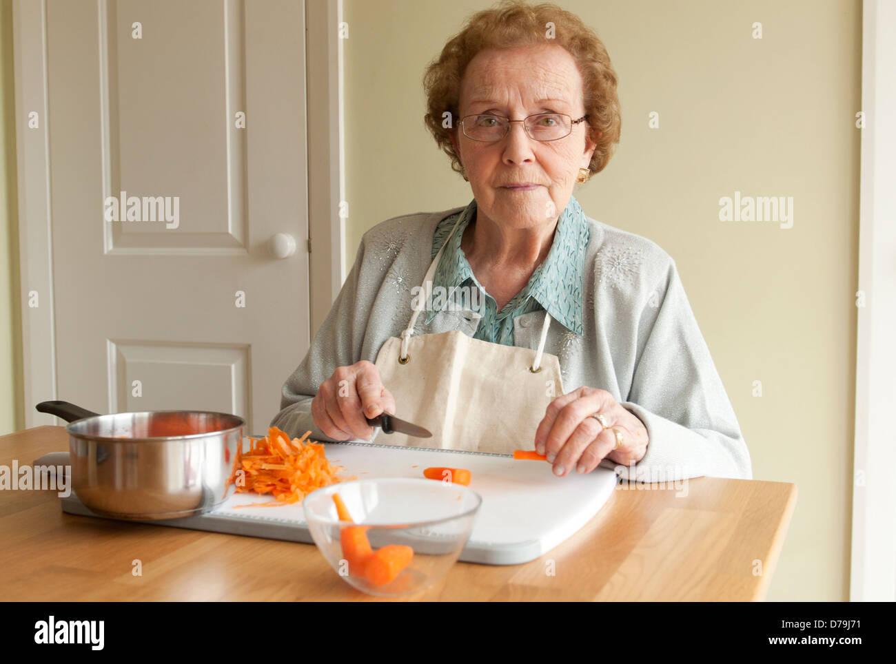 Femme âgée l'épluchage des carottes Banque D'Images