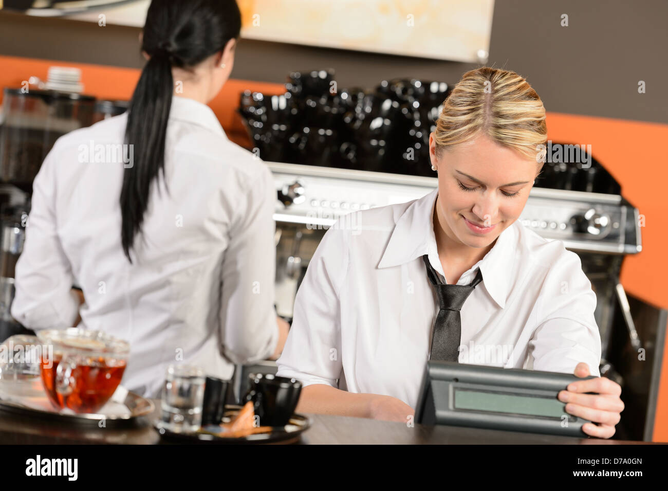 Heureux les serveuses travaillant au cafe en uniforme Banque D'Images