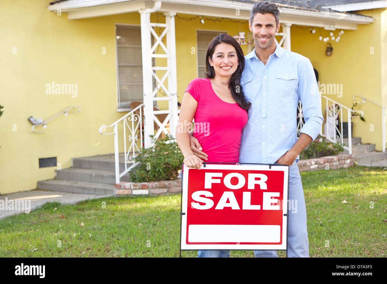 Couple Standing par For Sale Sign Outside Home Banque D'Images