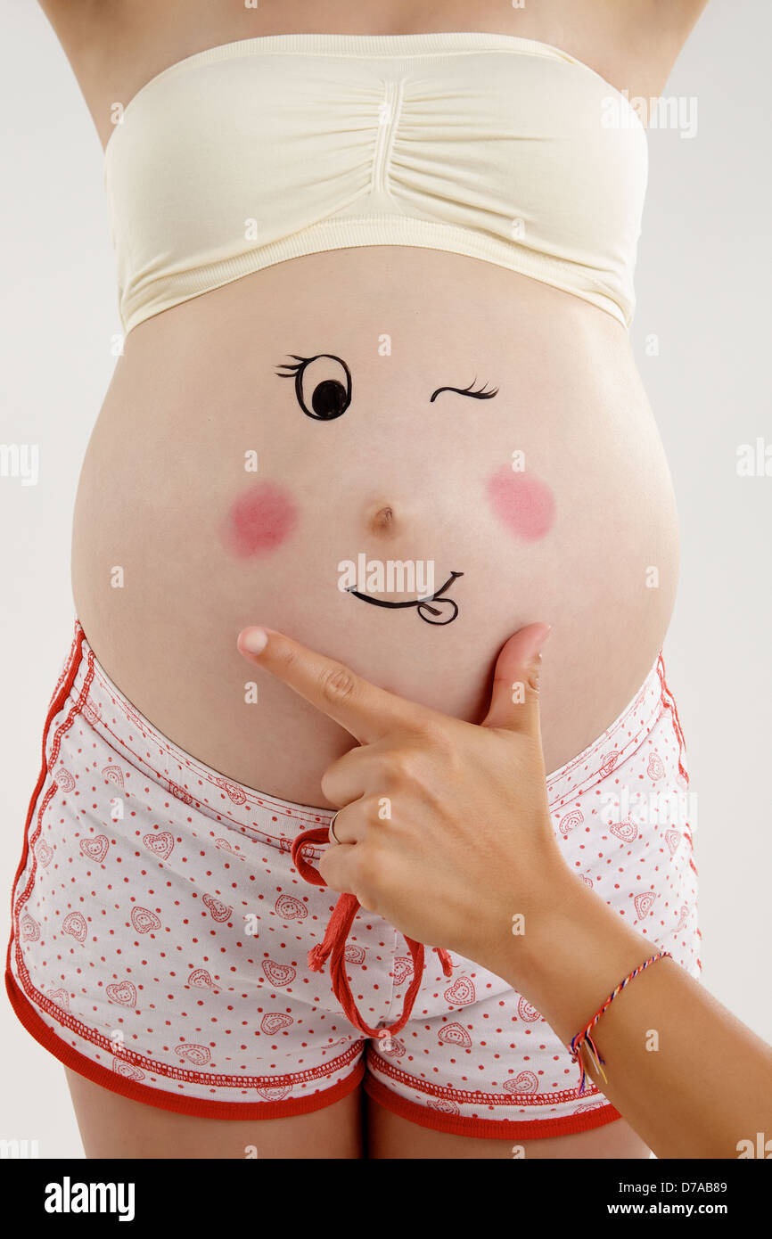 Une jeune femme enceinte avec un visage dessin sur son ventre Photo Stock -  Alamy