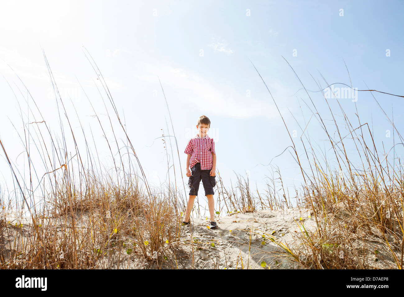 Enfant debout sur le haut de la dune de sable Banque D'Images