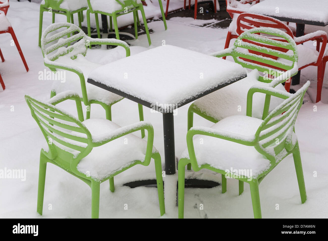 Des chaises et des tables couvertes de neige au début du printemps Banque D'Images