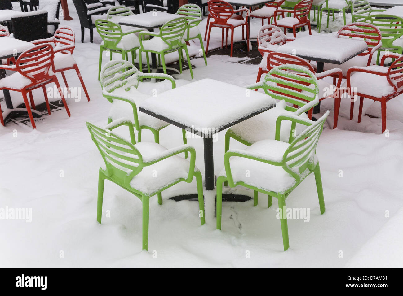 Des chaises et des tables couvertes de neige au début du printemps Banque D'Images