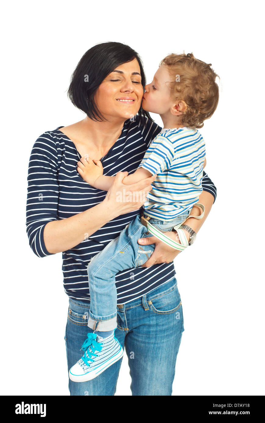 Tout-petit dans les bras de sa mère debout et l'embrassant joue isolé sur fond blanc Banque D'Images
