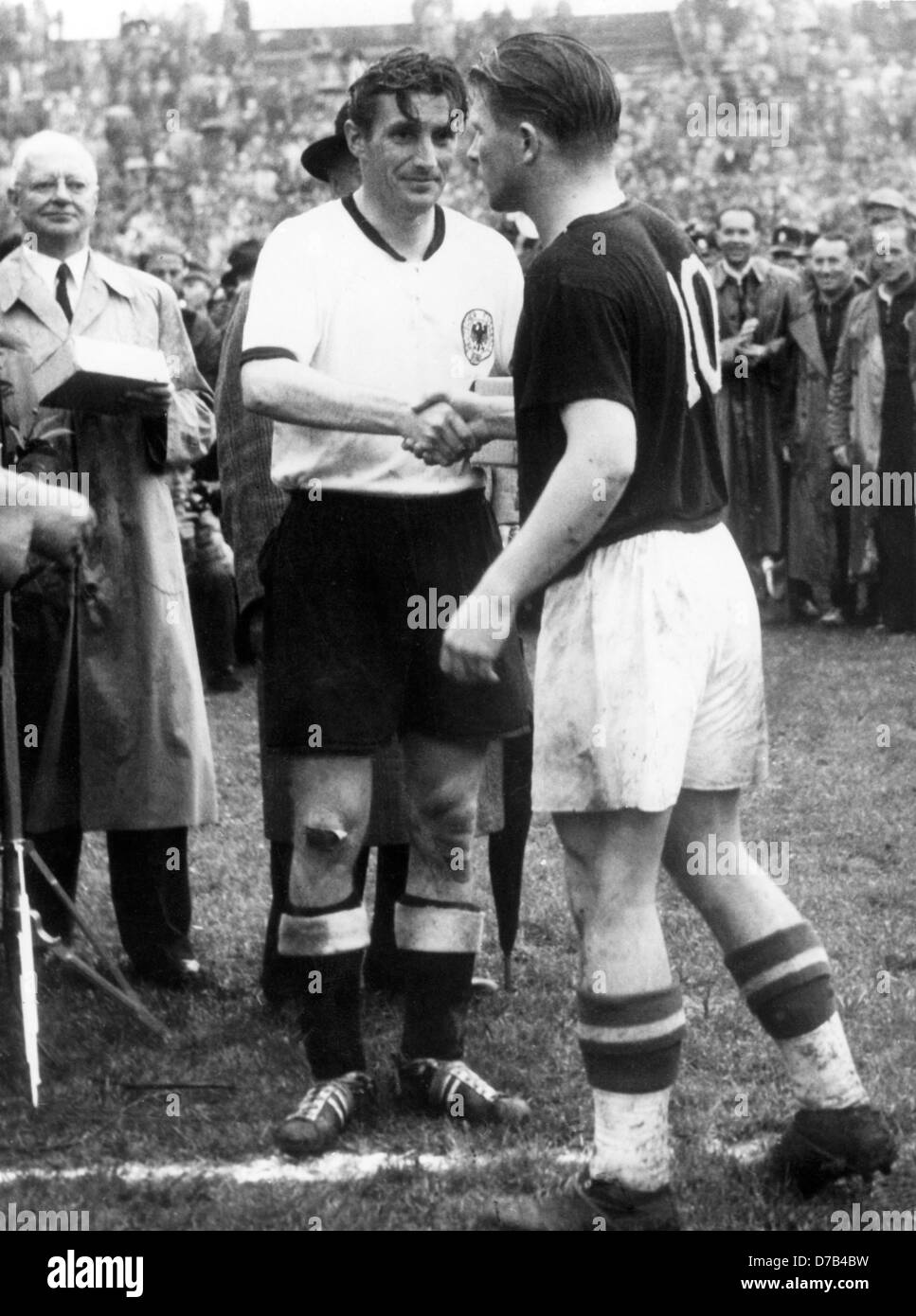 Le capitaine de l'équipe hongroise Ferenc Puskas (r) félicite le capitaine allemand Fritz Walter (l) sur la victoire allemande du championnat du monde le 4 juillet en 1954. L'Allemagne avait gagné contre la Hongrie avec 3:2. Dans l'arrière-plan à gauche le secrétaire général de la FIFA, Kurt Gassmann. Banque D'Images