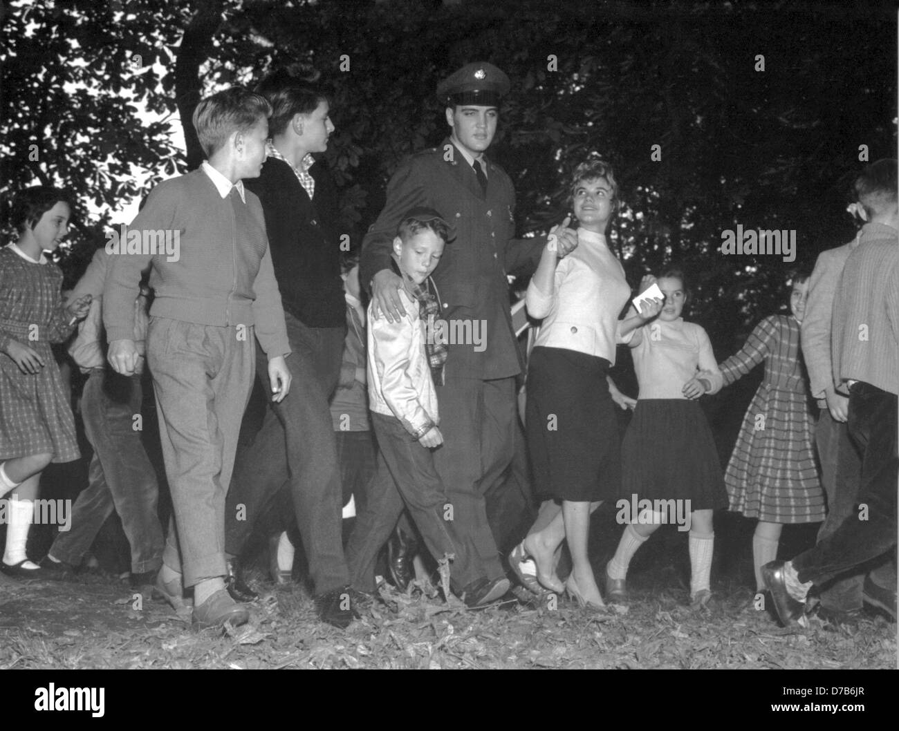 Elvis Presley va pour une promenade avec ses fans dans le parc de Bad Homburg le 5 octobre en 1958. Pour le plus grand plaisir de ses fans, l'American Rock'n Roll singer a été stationné à Friedberg (Hesse) dans le cadre de son service militaire dans l'armée américaine dans les années 1950. Banque D'Images