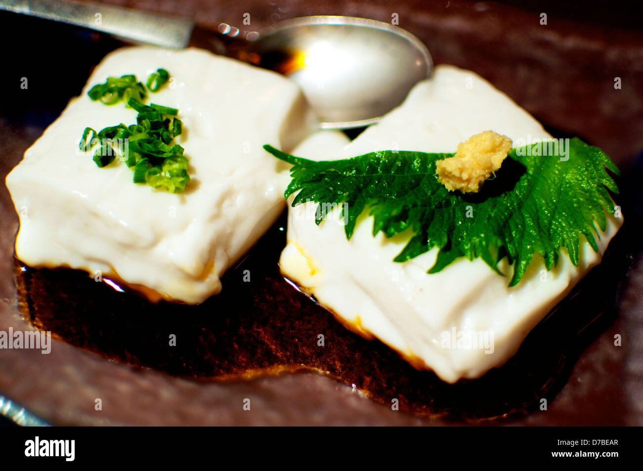 Deux petits morceaux de tofu japonais doux décoré d'une feuille de Shiso et gingembre Banque D'Images