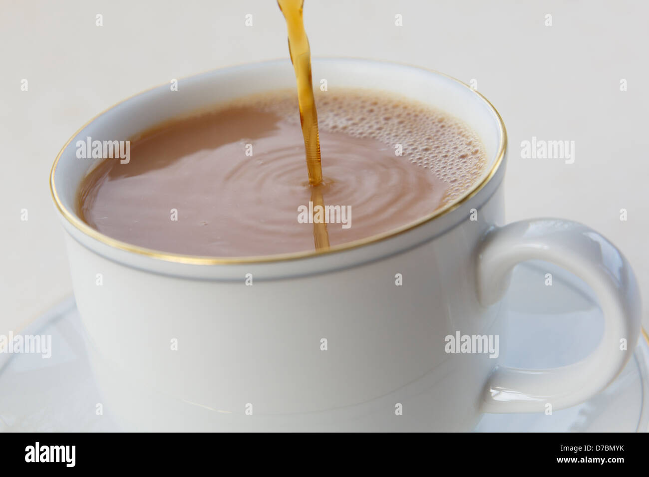 Verser le thé dans une tasse de Chine blanc. En Angleterre, Royaume-Uni, Angleterre Banque D'Images