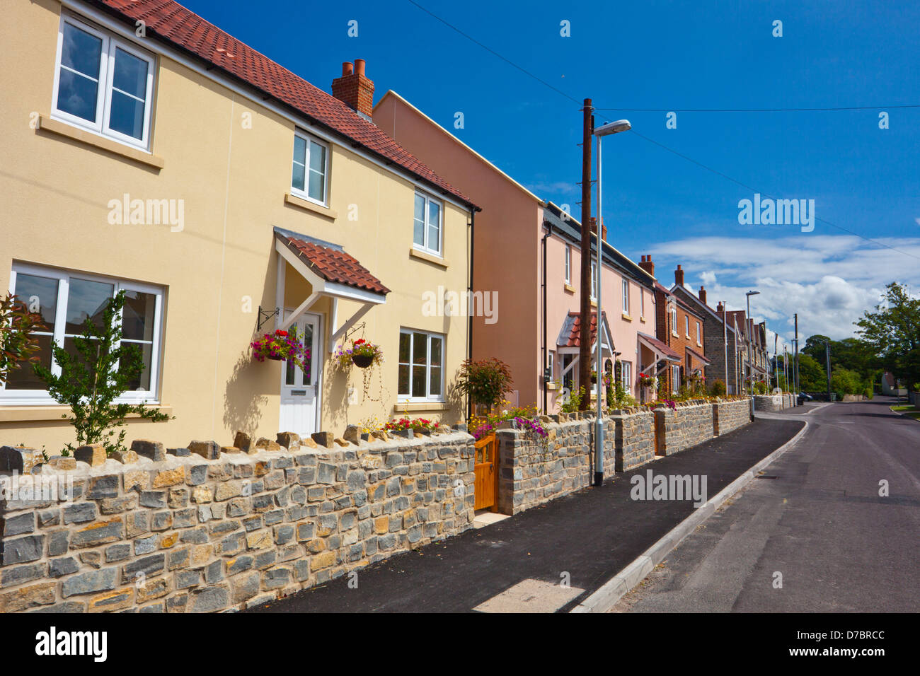 Une succession de nouveau construire des maisons dans le style et les couleurs de village traditionnel des chalets. Cossington, Somerset, England, UK Banque D'Images