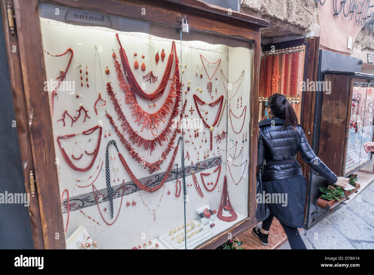Une femme entre dans une boutique de colliers de corail dans le centre historique d'Alghero, Sardaigne Banque D'Images