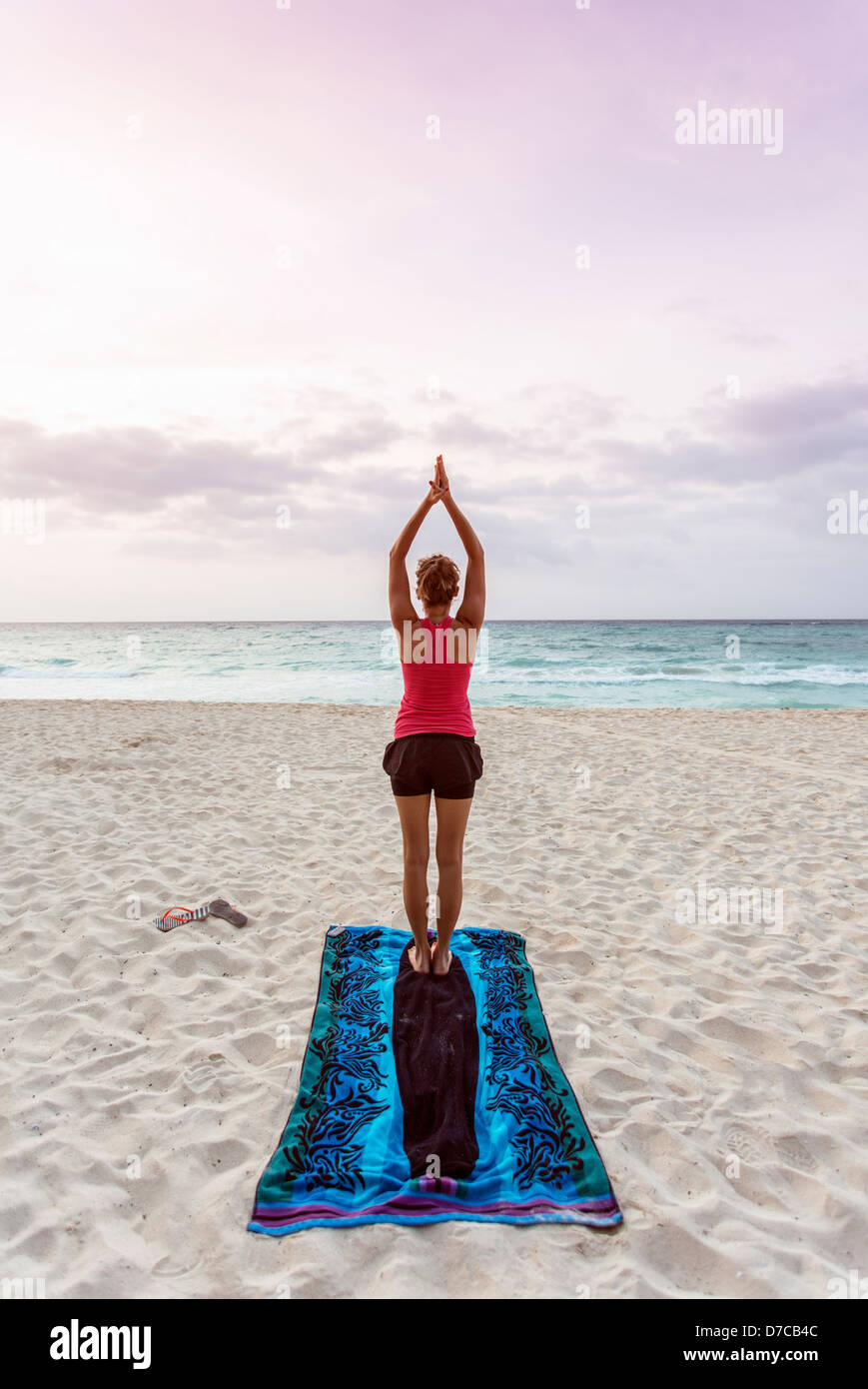 Le Mexique, Playa del Carmen, young woman practicing yoga on the beach at sun rise Banque D'Images