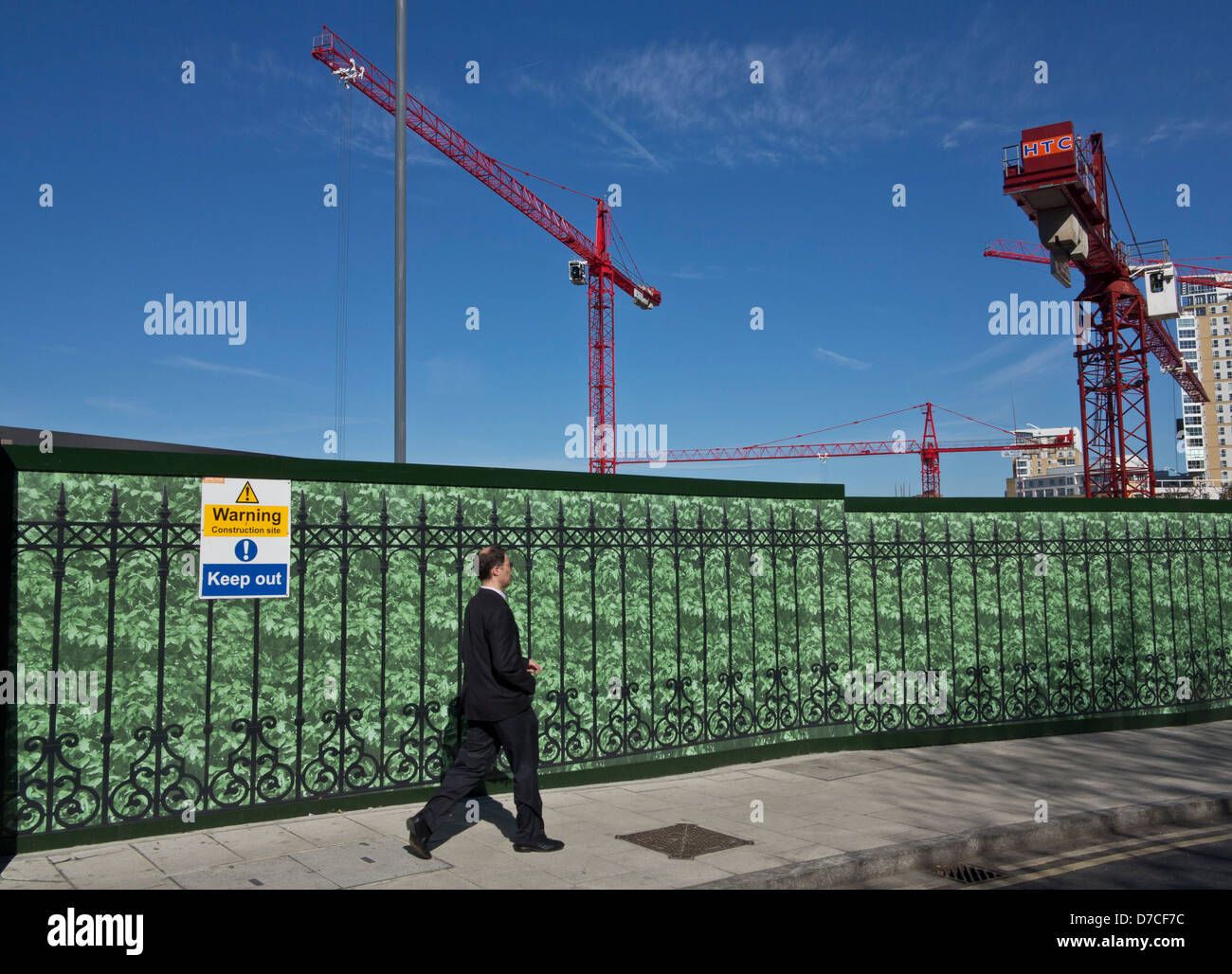 L'homme marche dernières nouvelles de la construction de bureaux à Canary Wharf, London, UK Banque D'Images