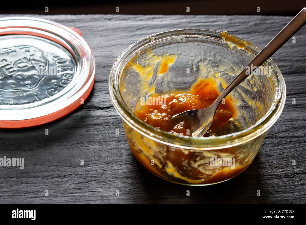 Pot de confiture ou de compote de rhubarbe sur fond d'ardoise. Banque D'Images