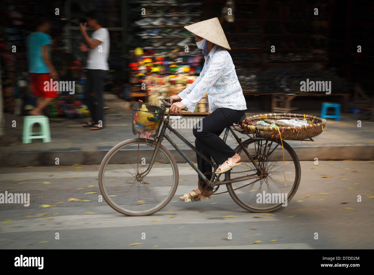 Un vendeur de rue sur son vélo dans le vieux quartier de Hanoi, Vietnam Banque D'Images