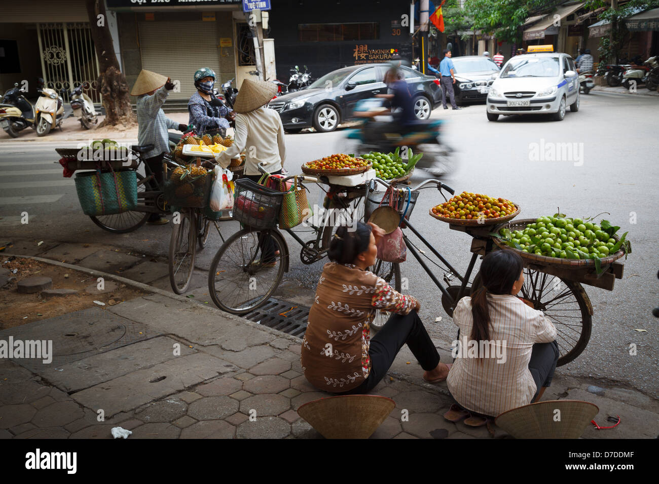 Les vendeurs de rue qui vendent leurs fruits sur leurs vélos dans le vieux quartier de Hanoi, Vietnam Banque D'Images