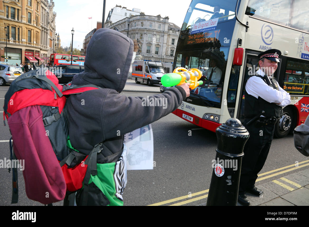 Londres, Royaume-Uni. 4e mai 2013. Protestataire visant un pistolet à eau pistolet à un policier à la UK Anonyme manifestation anti-austérité, Londres, Angleterre. Crédit : Paul Brown / Alamy Live News Banque D'Images