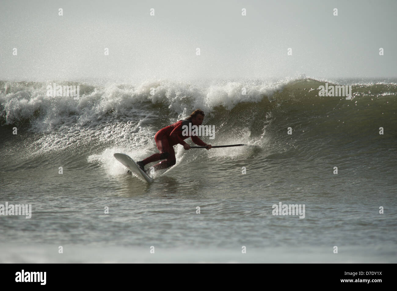 Stand Up Paddle board surfer Chris Griffiths, Champion britannique montre la voie classique de l'autre côté de la vague des surfeurs. Séquence. Gower surf. Banque D'Images