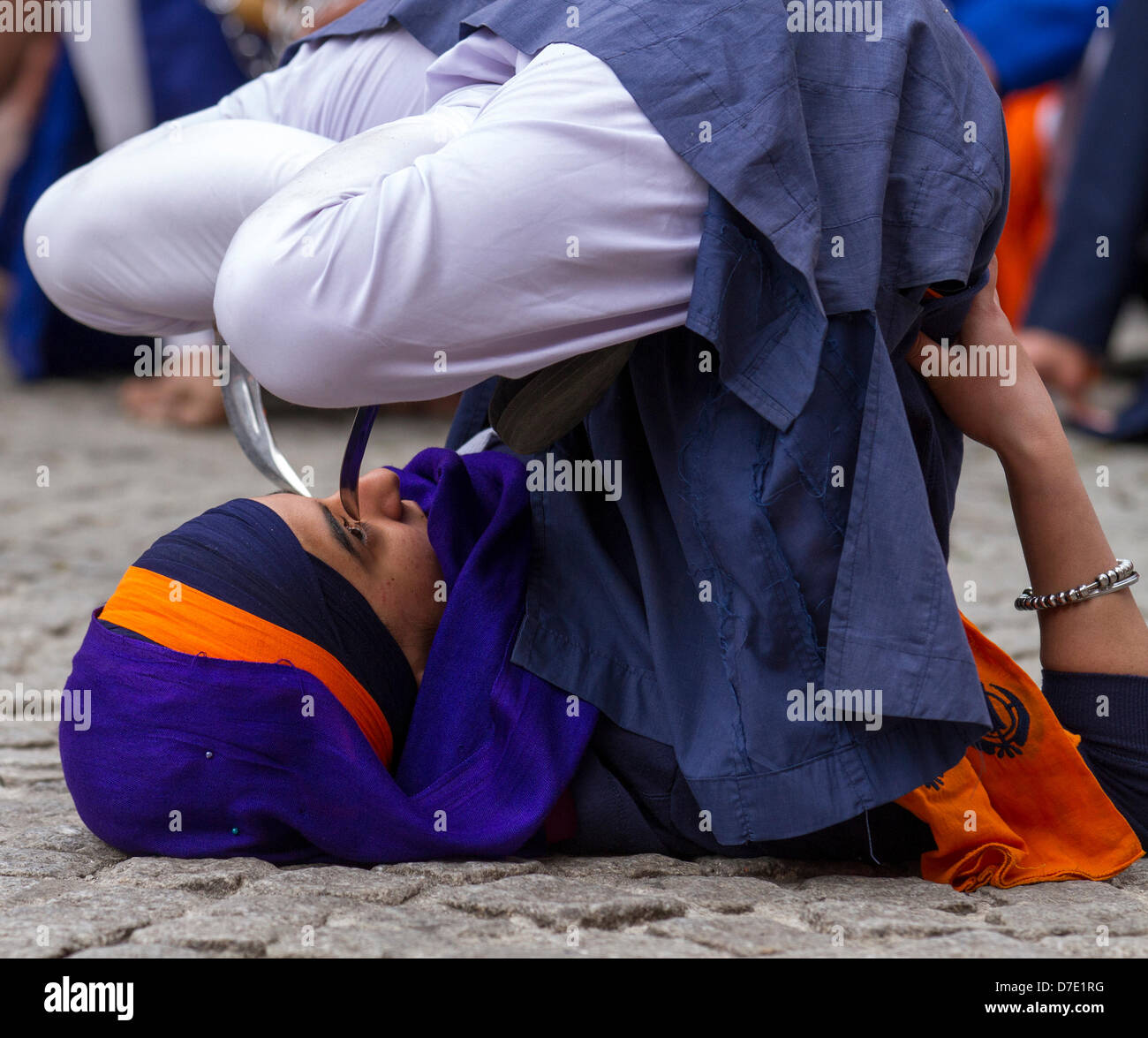 Sangar de Greater Manchester. Le Naga Kirtan Dimanche 5 Mai, 2013. Jeune fille de position des couteaux tenue à genoux sur ses yeux à la plus importante célébration du Vaisakhi dans le calendrier sikh marquée par la communauté sikh d'une plus grande et leur rapport annuel Nagar Kirtan procession dans les rues de Manchester. Le Keertan Nagar est couleur, la célébration et l'adoration et est une invitation à tous, sans distinction de caste, de religion et de croyance pour pouvoir rejoindre les Sikhs dans la célébration de leur religion et de la culture. Banque D'Images