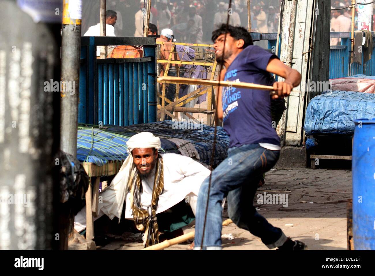 Dhaka, Bangladesh. 5 mai, 2013. Les partisans de l'Hefajat-e Islam et Islami Chhatra Shibir jeter les briques et pierres et allumer des feux au cours d'affrontements avec la police lors d'un rassemblement à Paltan à Dhaka, au Bangladesh. Des milliers d'Islamistes a Dhaka à l'arrêt le 05 mai qu'ils ont exigé une loi anti-blasphème qui entraîne la peine de mort, et ont déclaré un travailleur a été tué dans des affrontements entre manifestants et policiers. Les partisans de la radicale Hefazat-e-Islam porteurs de bâtons et bloqué les principaux points d'entrée de la ville Banque D'Images