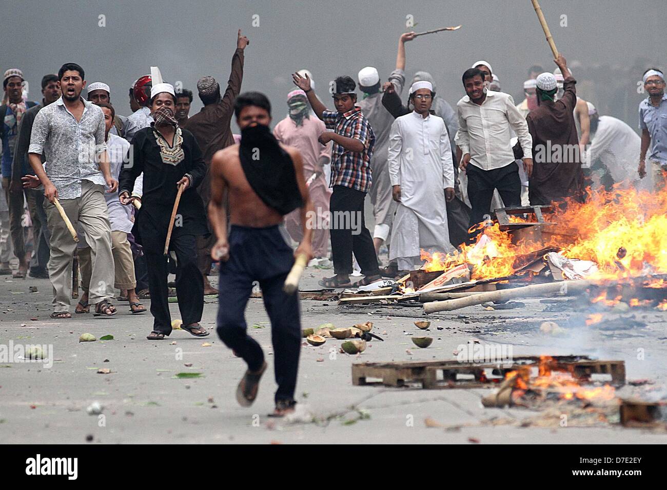 Dhaka, Bangladesh. 5 mai, 2013. Les partisans de l'Hefajat-e Islam et Islami Chhatra Shibir jeter les briques et pierres et allumer des feux au cours d'affrontements avec la police lors d'un rassemblement à Paltan à Dhaka, au Bangladesh. Des milliers d'Islamistes a Dhaka à l'arrêt le 05 mai qu'ils ont exigé une loi anti-blasphème qui entraîne la peine de mort, et ont déclaré un travailleur a été tué dans des affrontements entre manifestants et policiers. Les partisans de la radicale Hefazat-e-Islam porteurs de bâtons et bloqué les principaux points d'entrée de la ville Banque D'Images