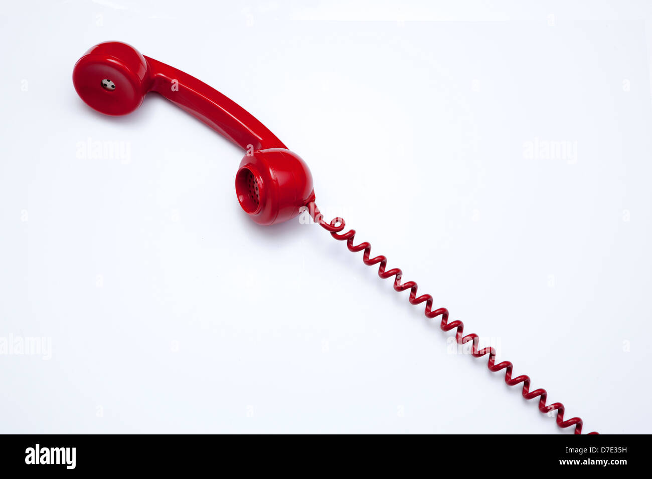 Un récepteur téléphonique rouge, 1960 d'origine et cordon de téléphone. Banque D'Images