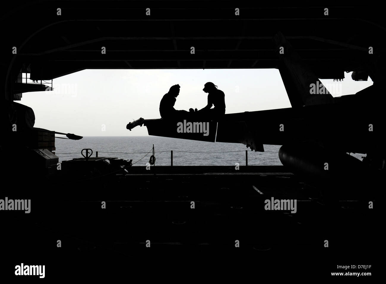 Effectuer les marins d'entretien sur un F/A-18C Hornet. Banque D'Images