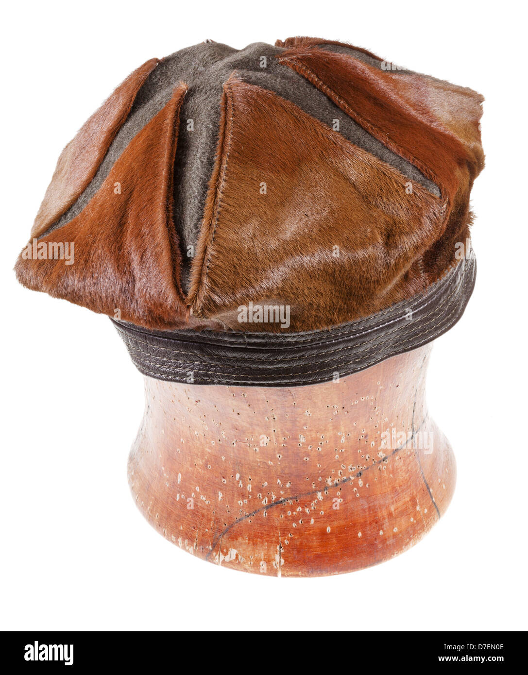 Pelage brun beret hat sur un bloc en bois isolé sur fond blanc Banque D'Images
