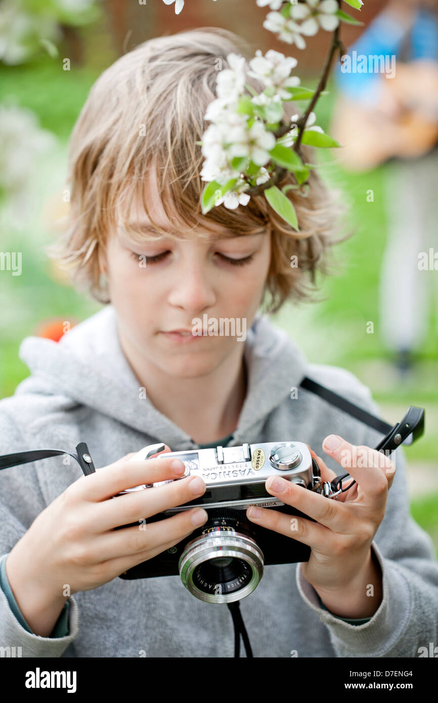 Garçon jouant avec un vieil appareil photo. Banque D'Images