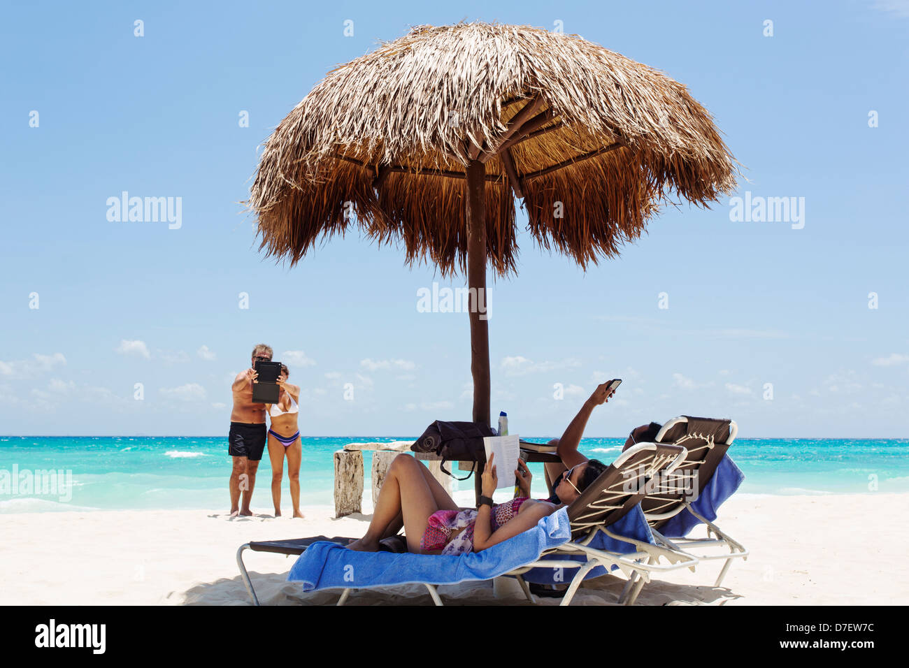 Les gens sur la plage à l'aide d'i-phone et i-pad Banque D'Images